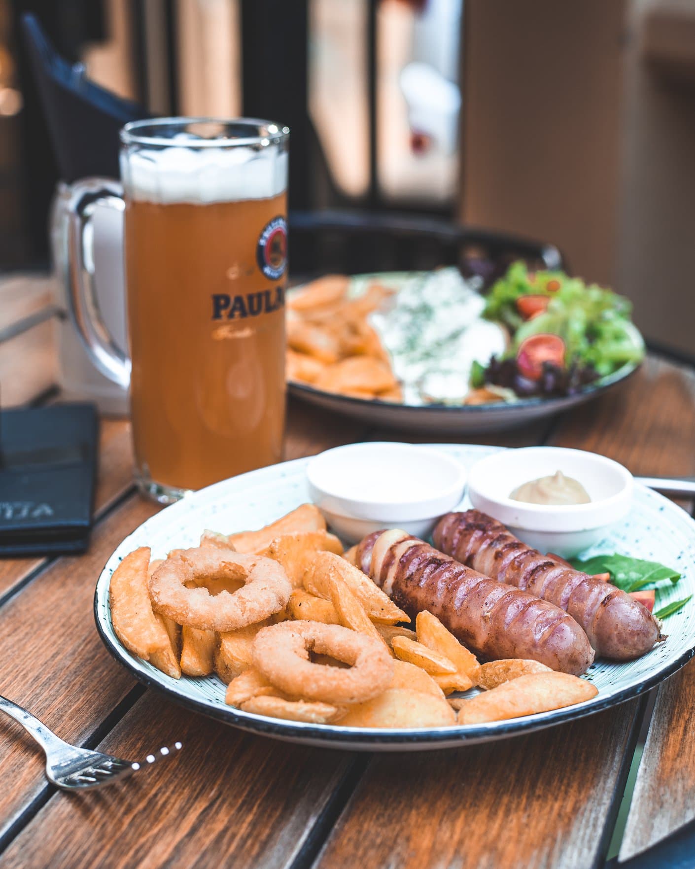 Kobasice sa začinjenim krompirom, onion rings i sosovima uz pivo
